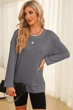 Charcoal waffle knit oversized top with slit hem and crew neck, styled with black shorts and a handbag.