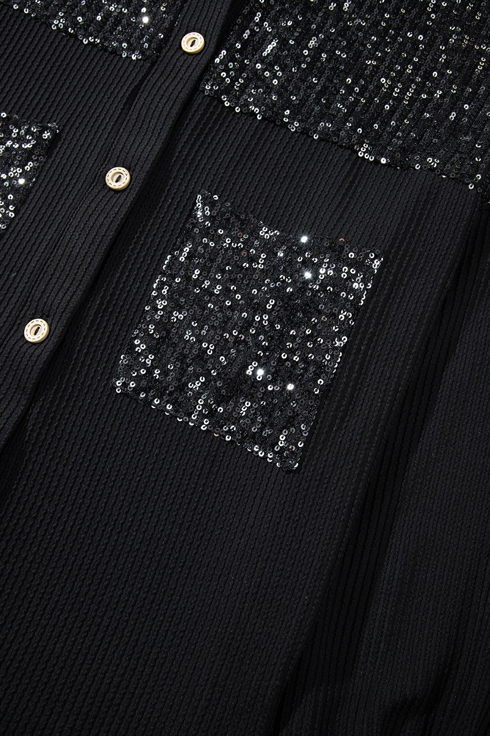 Black textured knit shirt jacket with sequin pockets and button front.