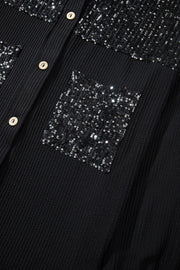 Black textured knit shirt jacket with sequin pockets and button front.