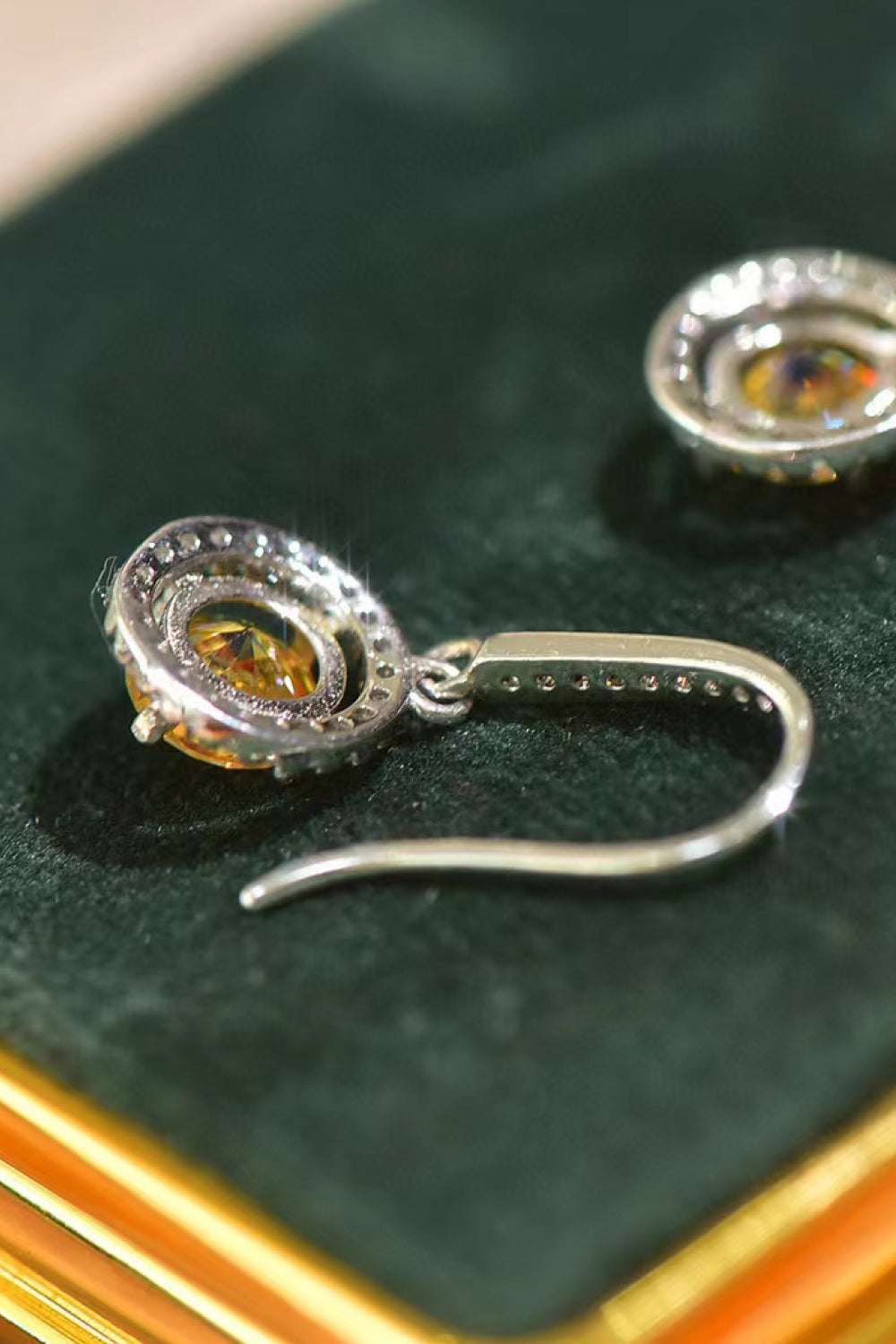Golden halo moissanite drop earrings with yellow and white stones.