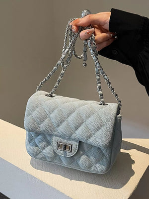 Quilted chain crossbody clutch in blue with silver hardware and a turn-lock closure.
