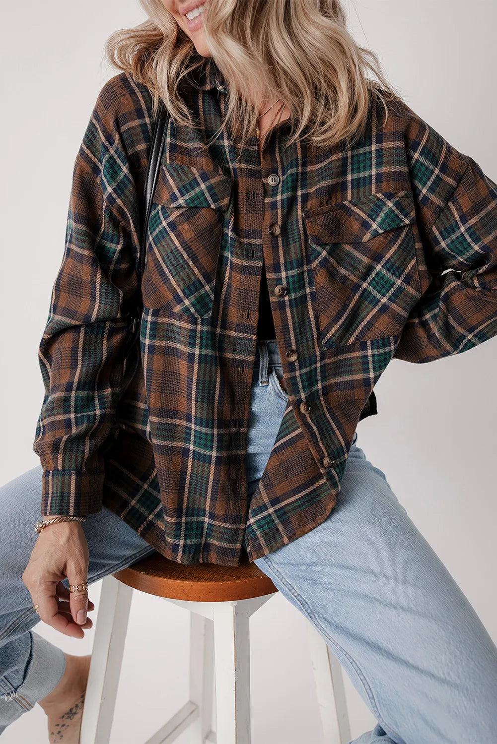 Plaid snap jacket in brown, green, and navy with button details and chest pockets.