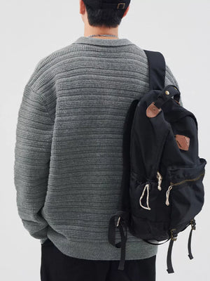 Men's gray ribbed knit cardigan with a collar, styled with a black backpack.