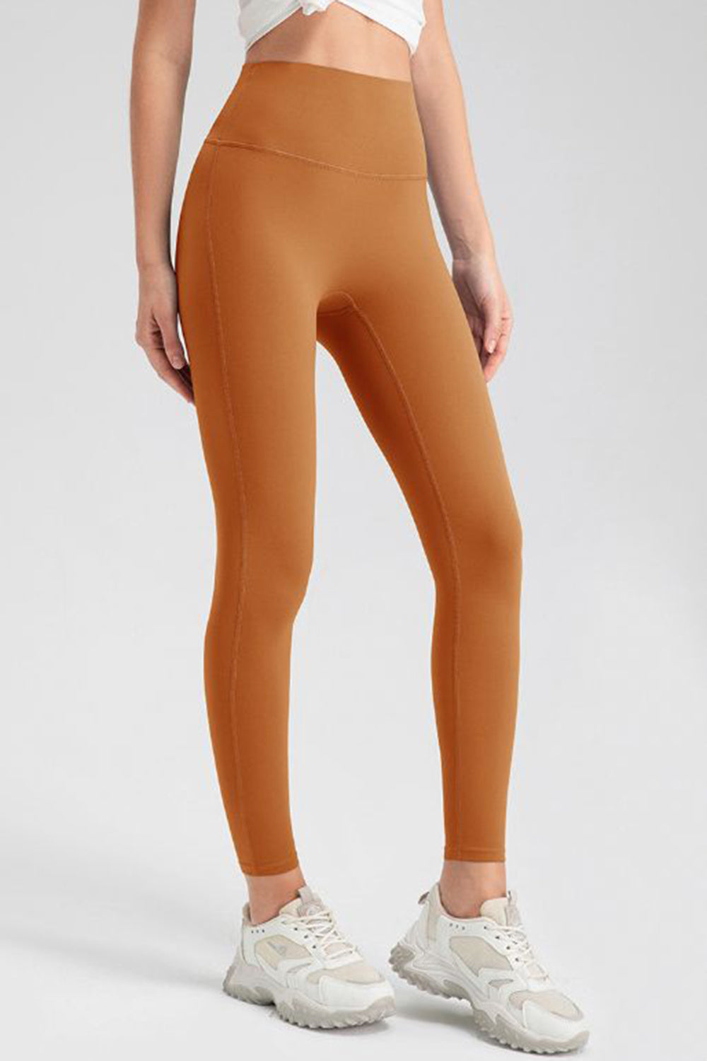 Caramel high-waist performance leggings with sculpting seams.