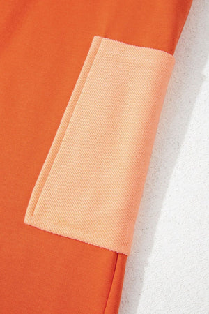 Orange colorblock romper with a patch pocket detail.