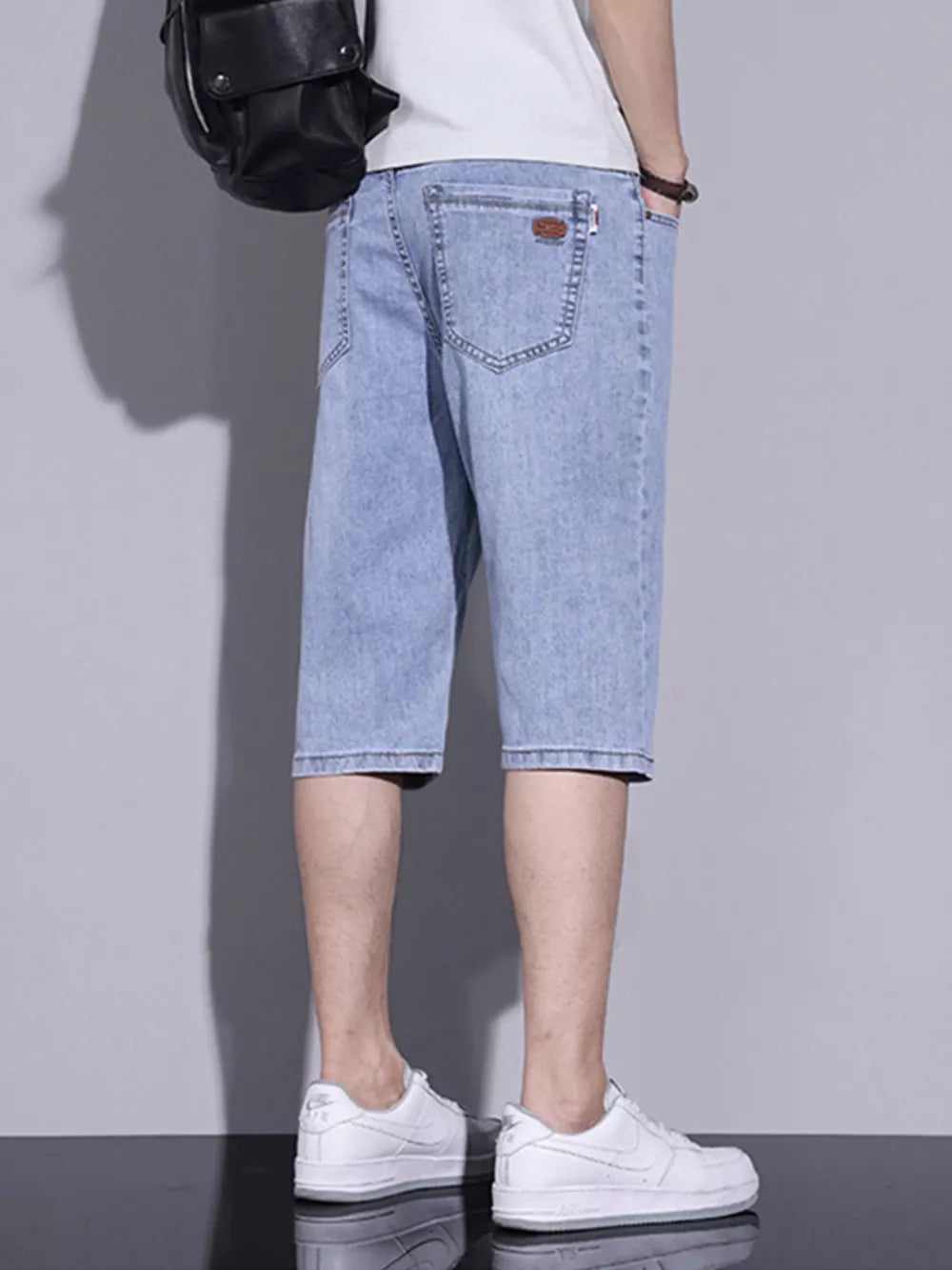 Men's light blue washed denim shorts with classic fit and button closure.