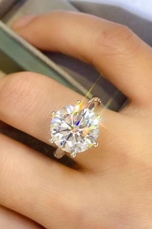 Silver solitaire engagement ring with a large round-cut diamond and pave band.