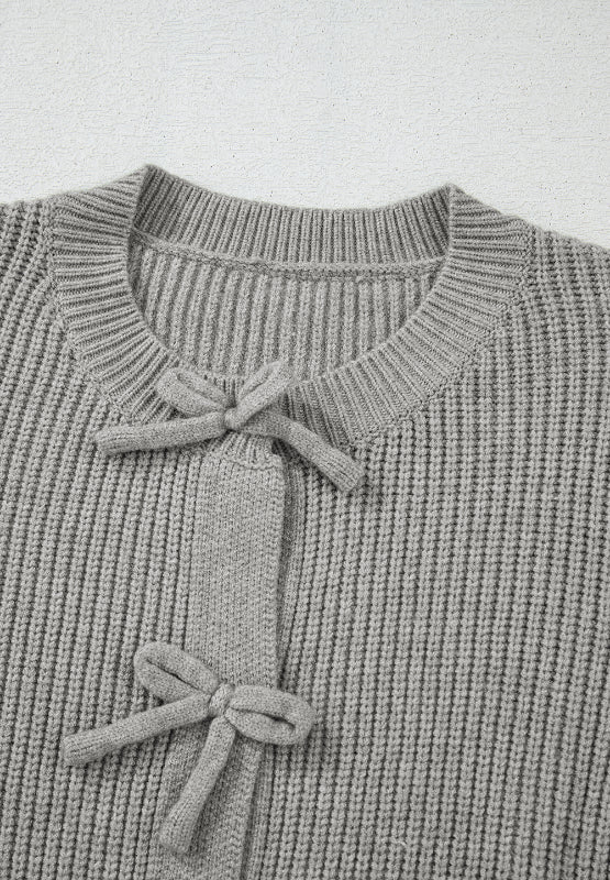 Gray ribbed knit cardigan with tie-front detail and bow accents.