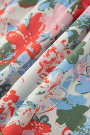 Maxi dress with abstract floral print in red, blue, pink, and green on white fabric.
