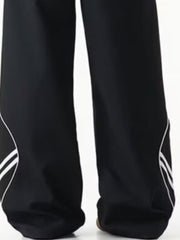Men's black wide leg track pants with white stripe detail on the side.