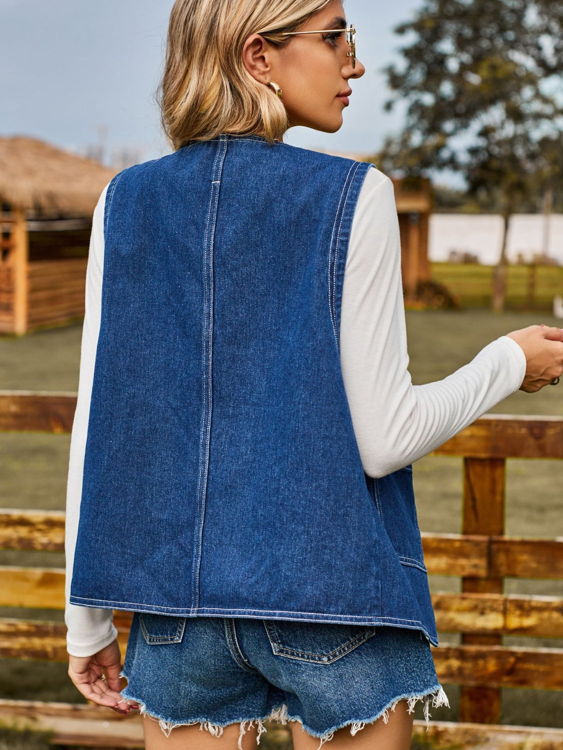 Dark blue denim vest with red heart buttons, casual buttoned outerwear.