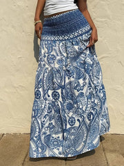 Bohemian maxi skirt in blue paisley print with smocked waist and tiered ruffles.