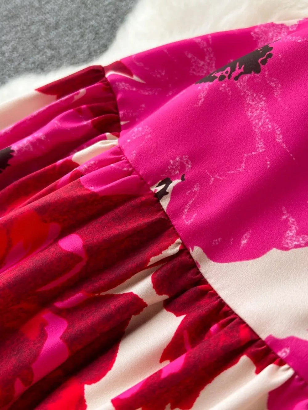 Vibrant floral tiered cami dress with ruffled details in pink and red.
