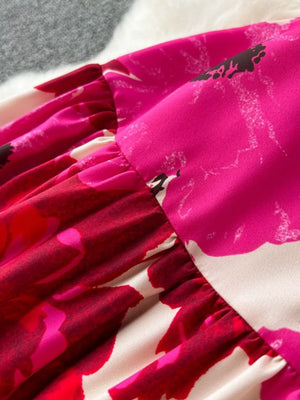 Vibrant floral tiered cami dress with ruffled details in pink and red.