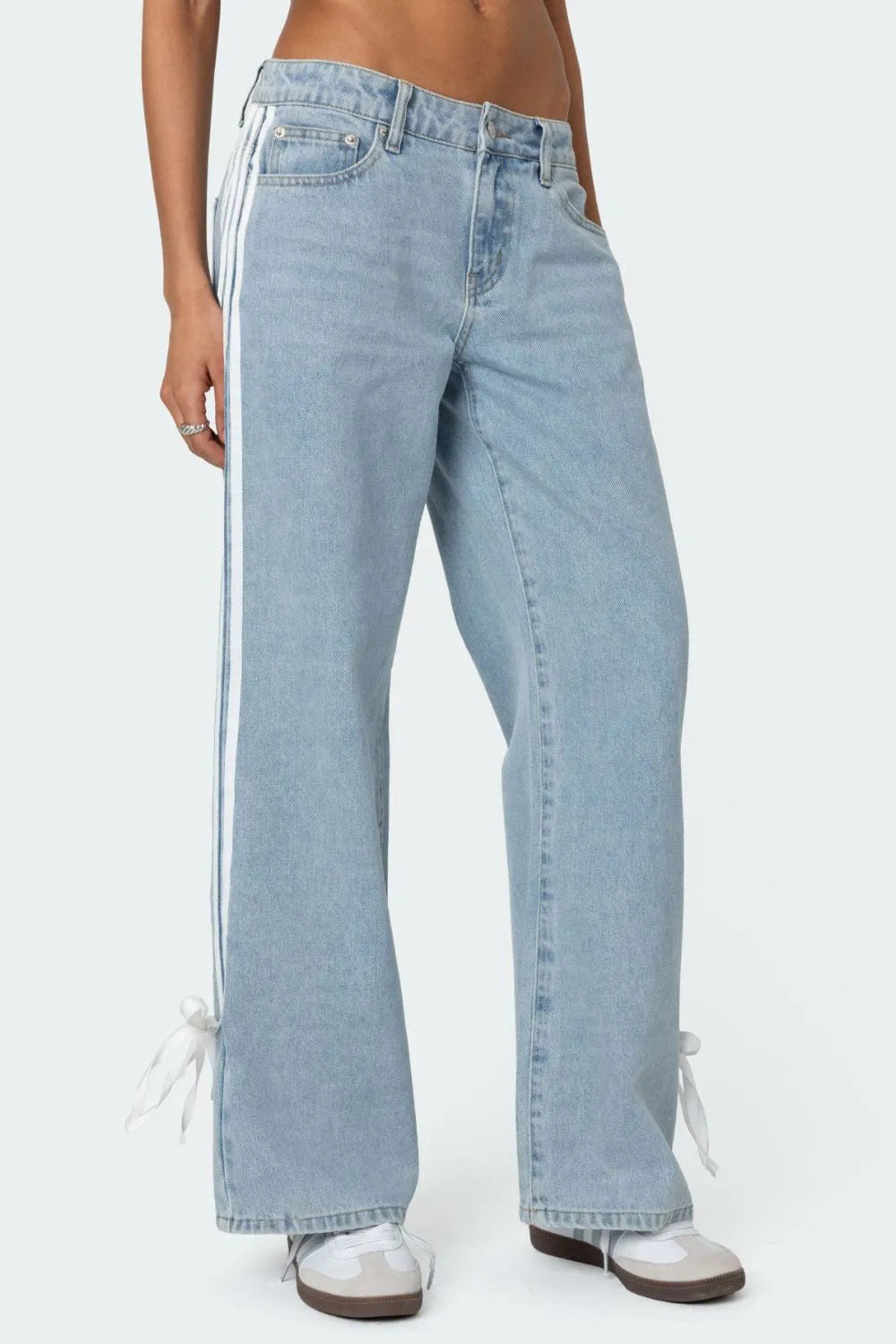 Light blue denim wide-leg trousers with white side stripes and ankle ties.