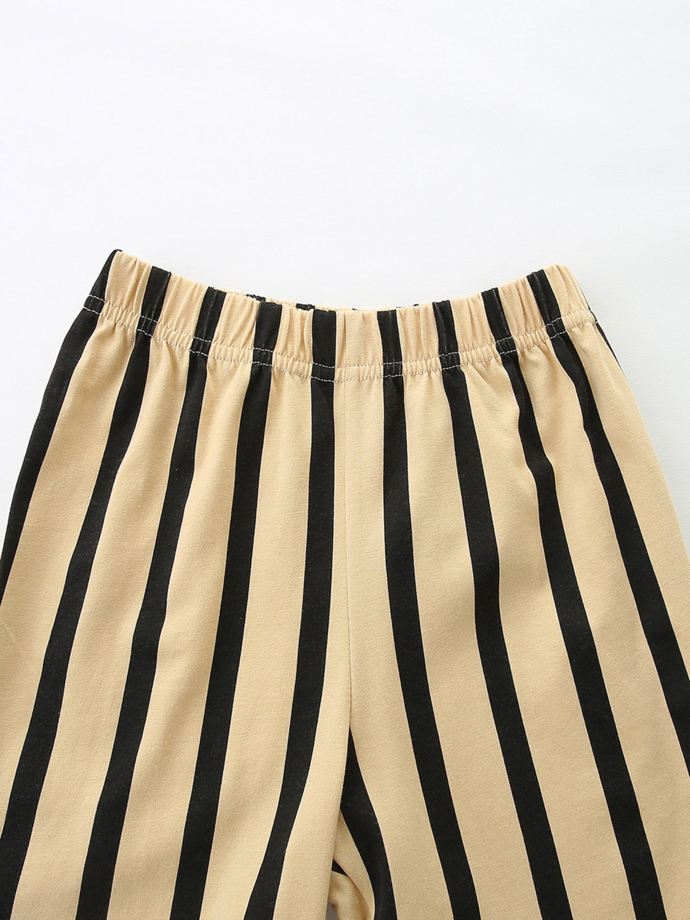 Baby shorts with beige and black vertical stripes and elastic waistband.