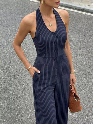 Navy pinstripe halter jumpsuit with decorative buttons and pockets.