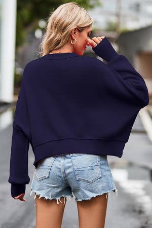 Dark blue ribbed knit batwing sweater with cropped length and crew neck.