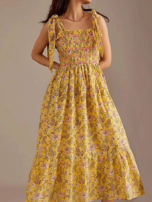 Yellow floral midi dress with smocked bodice and tie shoulders.