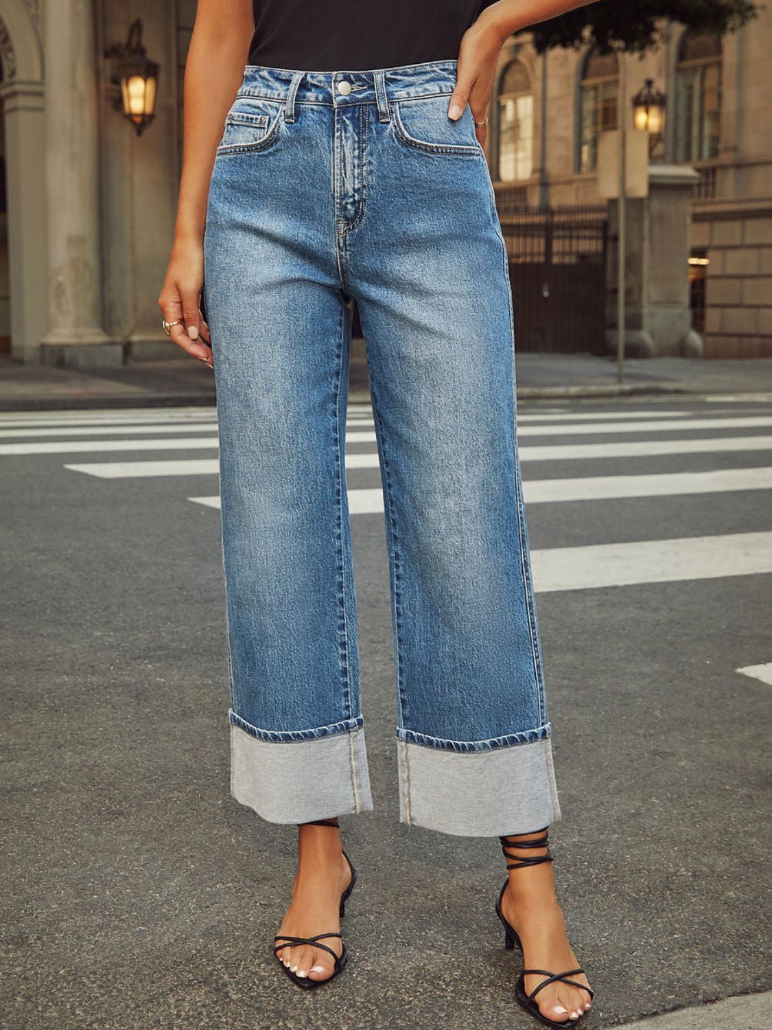 Light wash denim jeans with wide legs and cuffed hems.