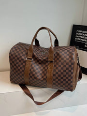 Chic checkered travel bag with brown leather accents and adjustable strap.