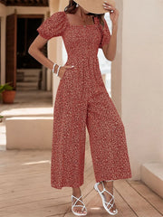 Rust floral print wide leg jumpsuit with smocked bodice and puff sleeves.