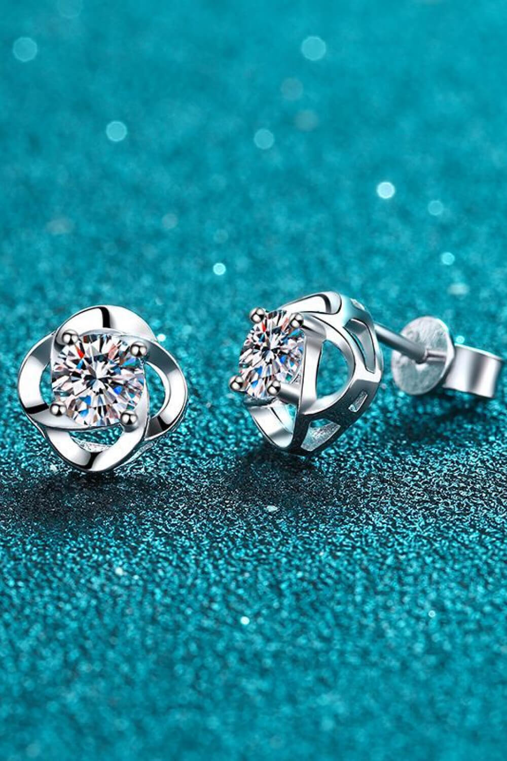 Silver four-leaf clover stud earrings with a central sparkling stone.