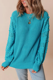 Turquoise knit sweater with textured cutout sleeves and crew neck.