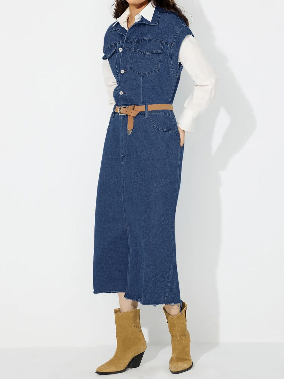 Sleeveless dark wash denim midi dress with button front, slit, and frayed hem.