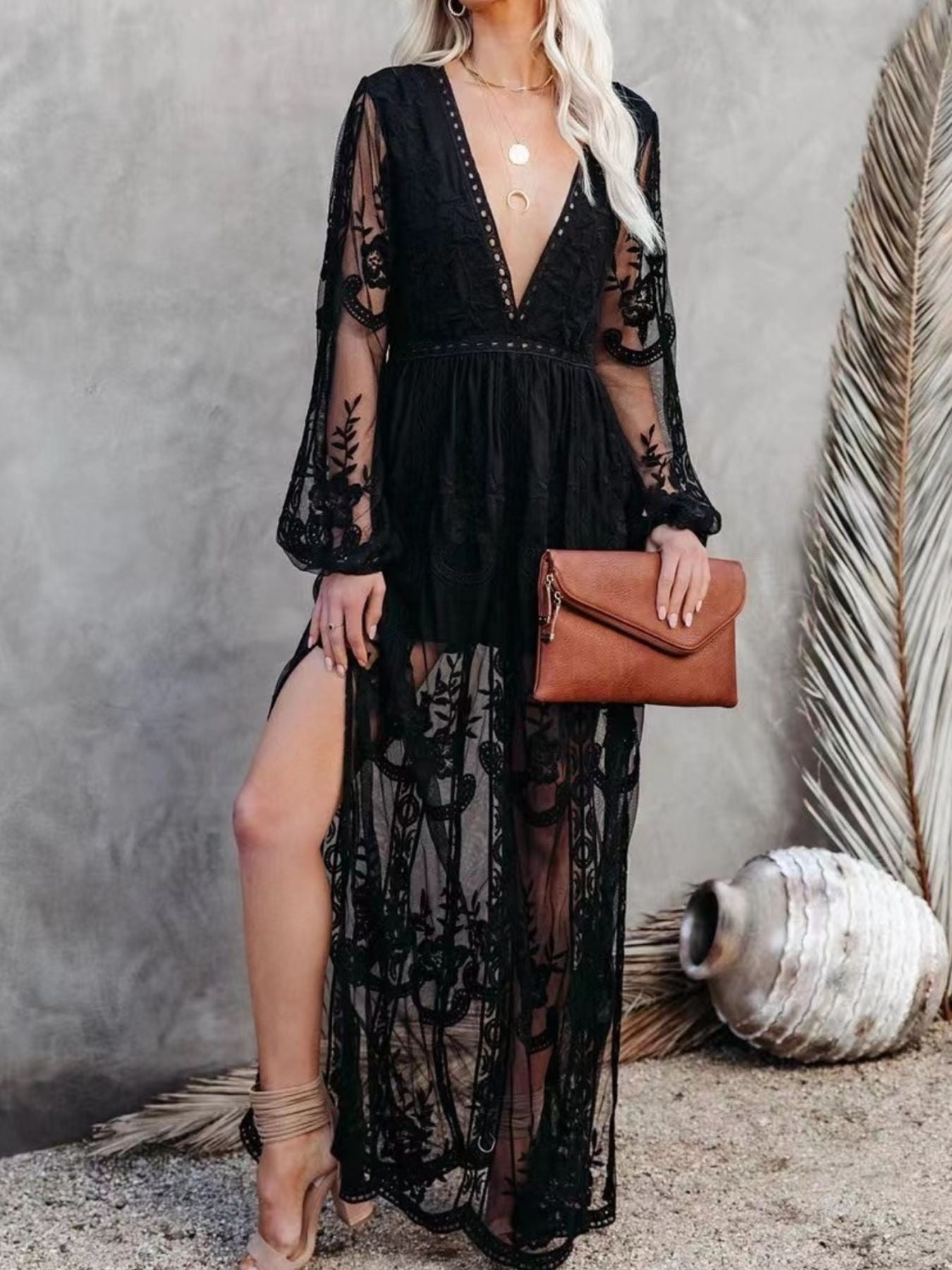 Black lace maxi dress with plunging neckline, long sheer sleeves, and high slit.