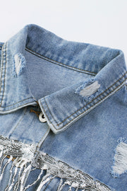 Medium wash denim trucker jacket with distressed details and sequin fringe.