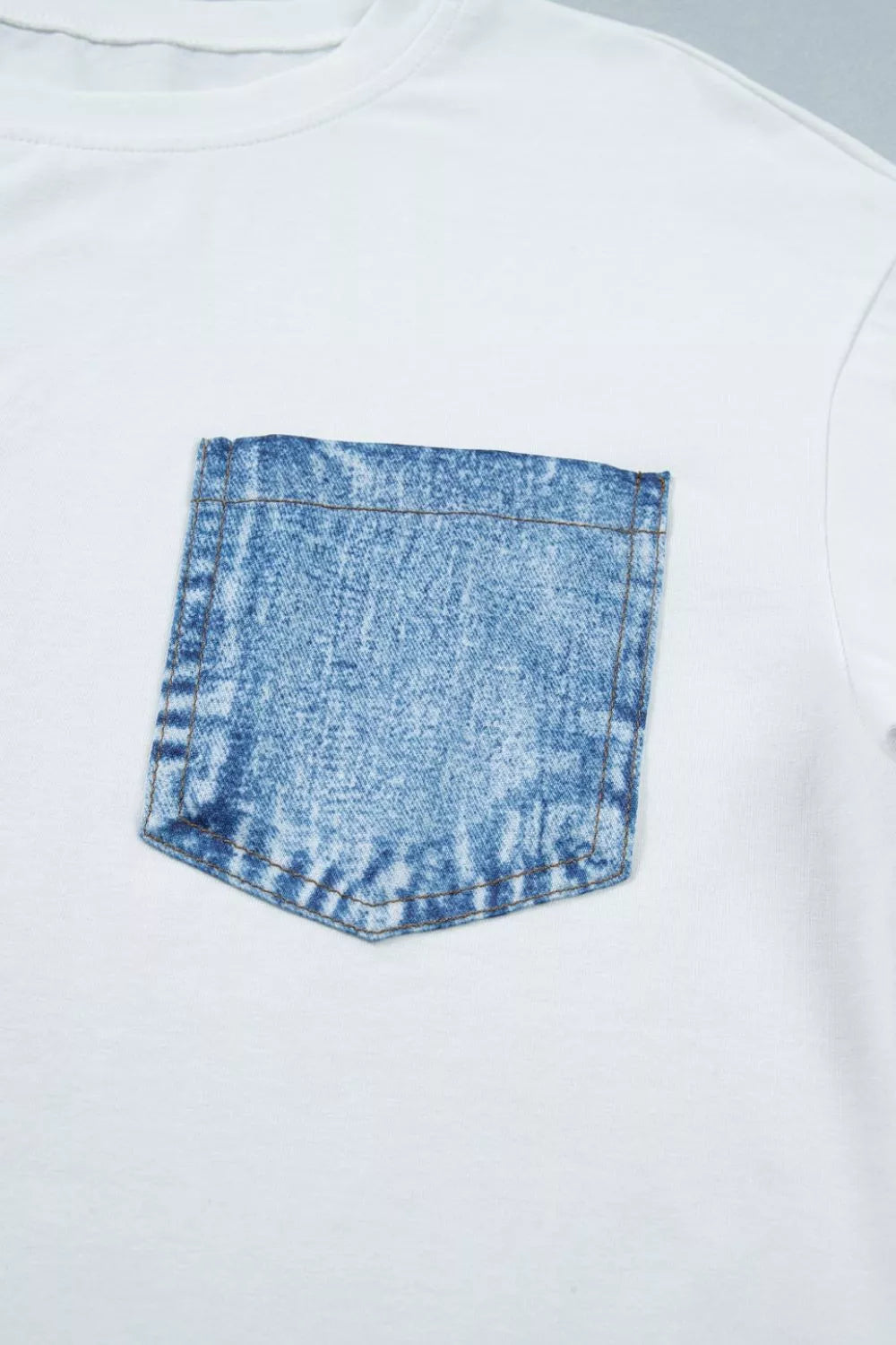 White cotton tee with a blue acid wash denim pocket detail