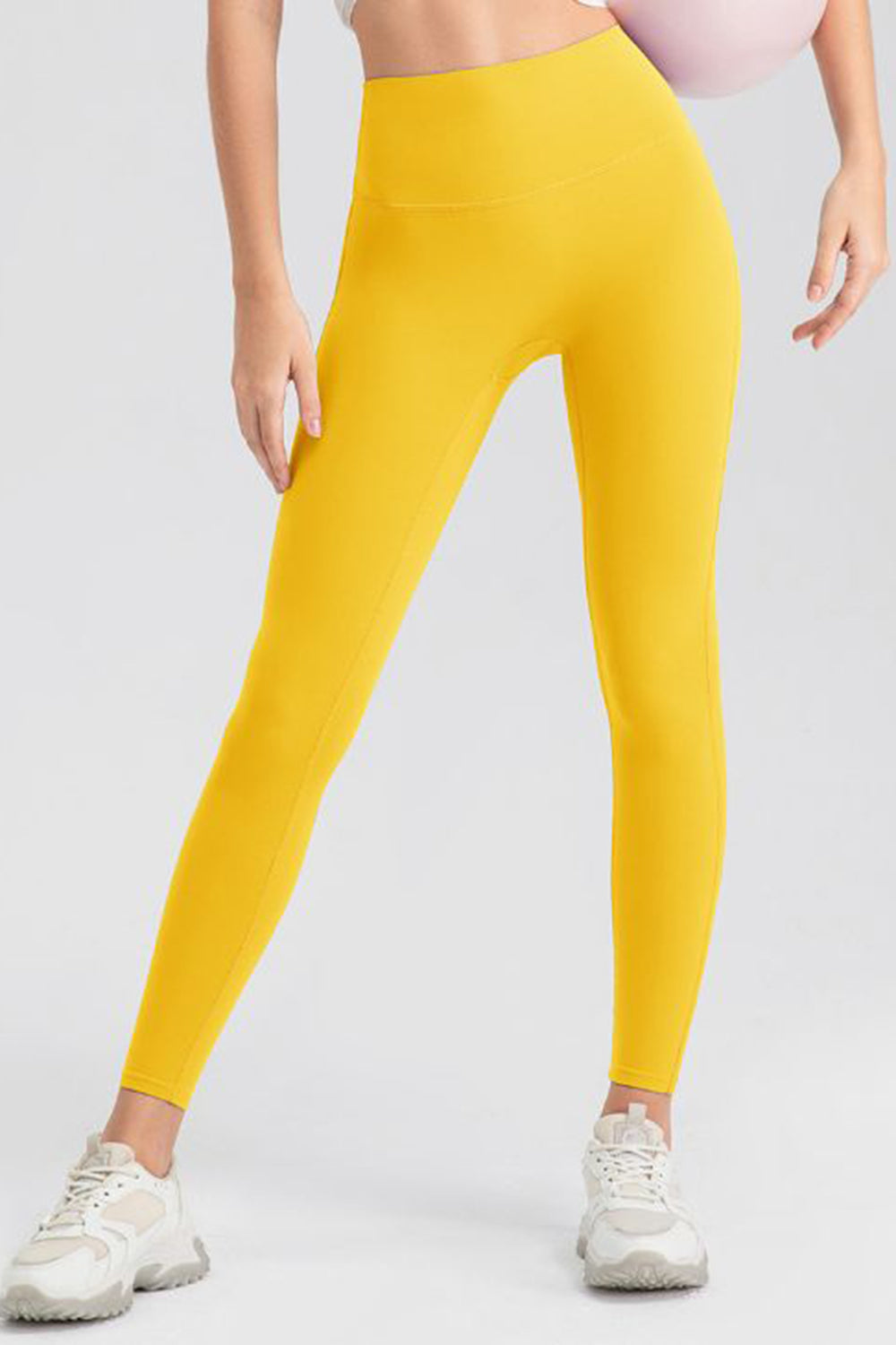 Yellow high-waist performance leggings with sculpting seams.