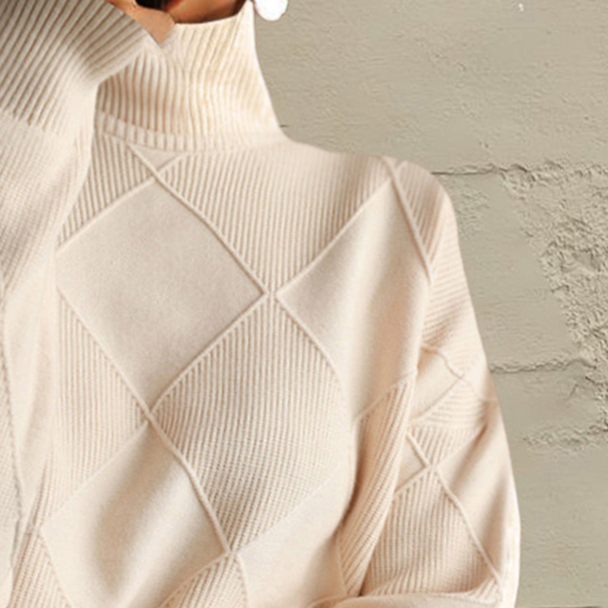 Ivory turtleneck pullover sweater with diamond knit pattern and ribbed texture.