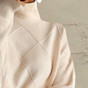 Ivory turtleneck pullover sweater with diamond knit pattern and ribbed texture.