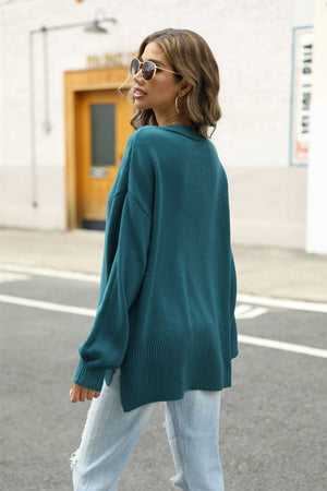 Turquoise relaxed knit pullover sweater with side slits and ribbed hem.