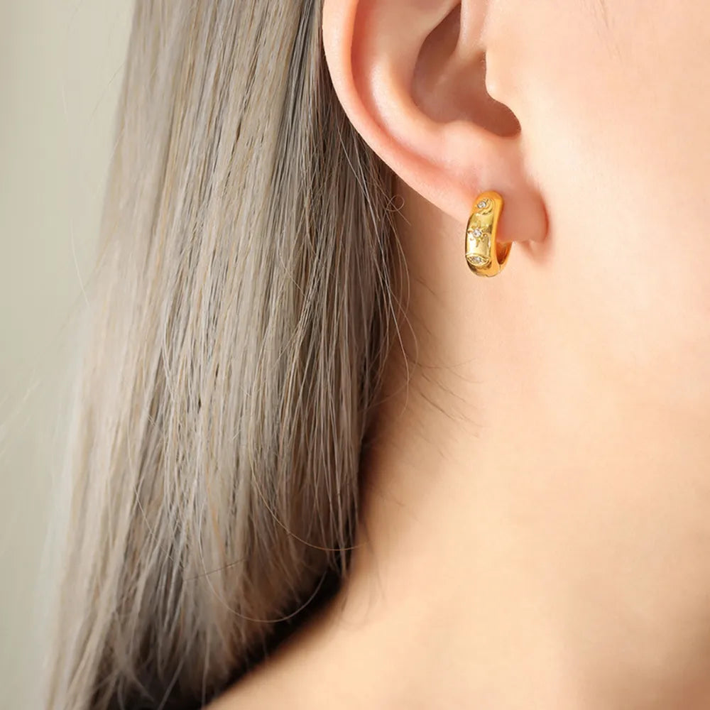 Gold mini huggie hoop earrings with zirconia embellishments.