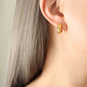 Gold mini huggie hoop earrings with zirconia embellishments.