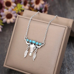 Silver necklace with turquoise stones and bull skull pendant with feather charms