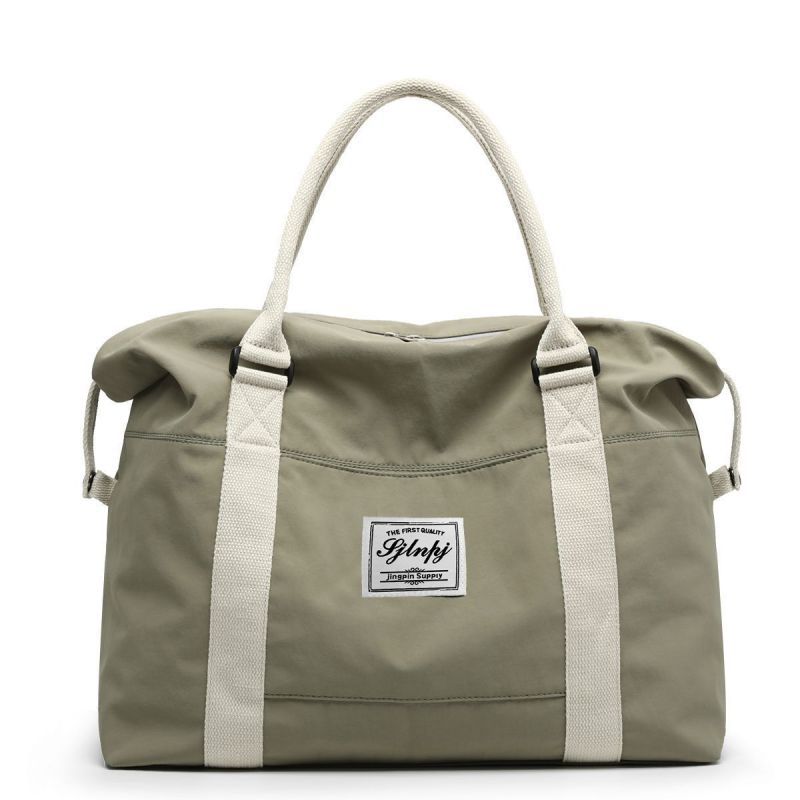 Sage green duffel bag with white straps and a white label with black text.