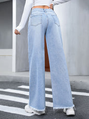 Light wash denim wide-leg jeans with fray hem and distressed details.