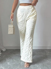 Textured white high-waist wide-leg maternity trousers with pockets, styled with a crop top and basket bag.