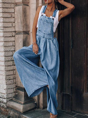 Light wash denim overalls palazzo jumpsuit with wide legs and a bib pocket.