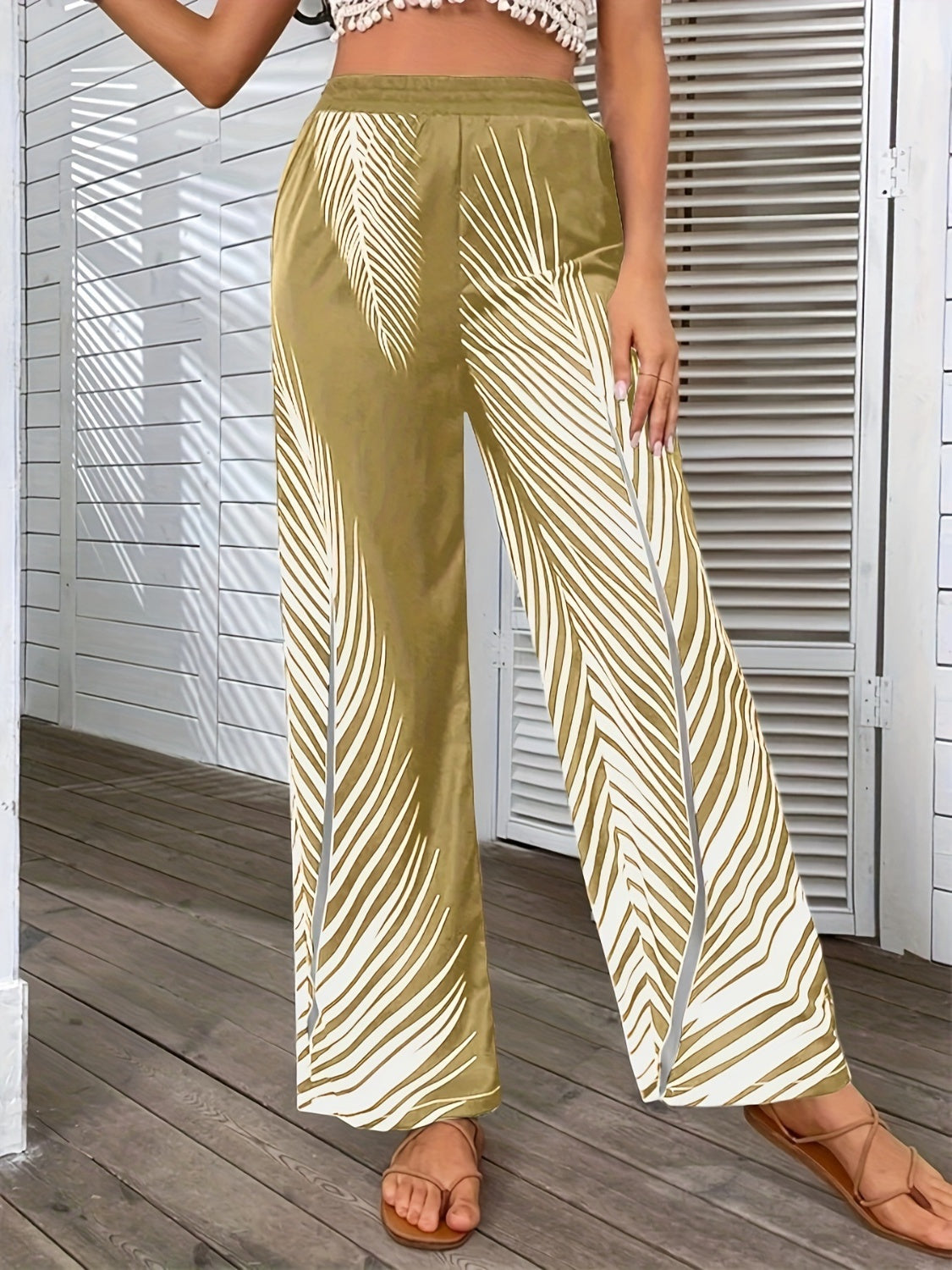 Palm print palazzo trousers in khaki with white palm leaf pattern and side slits.