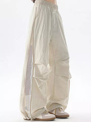 Cream cargo sweatpants with adjustable waist and mesh side detail.