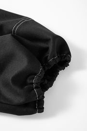 Black puff sleeve blouse with contrast white stitching and elastic cuff detail.