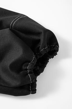 Black puff sleeve blouse with contrast white stitching and elastic cuff detail.