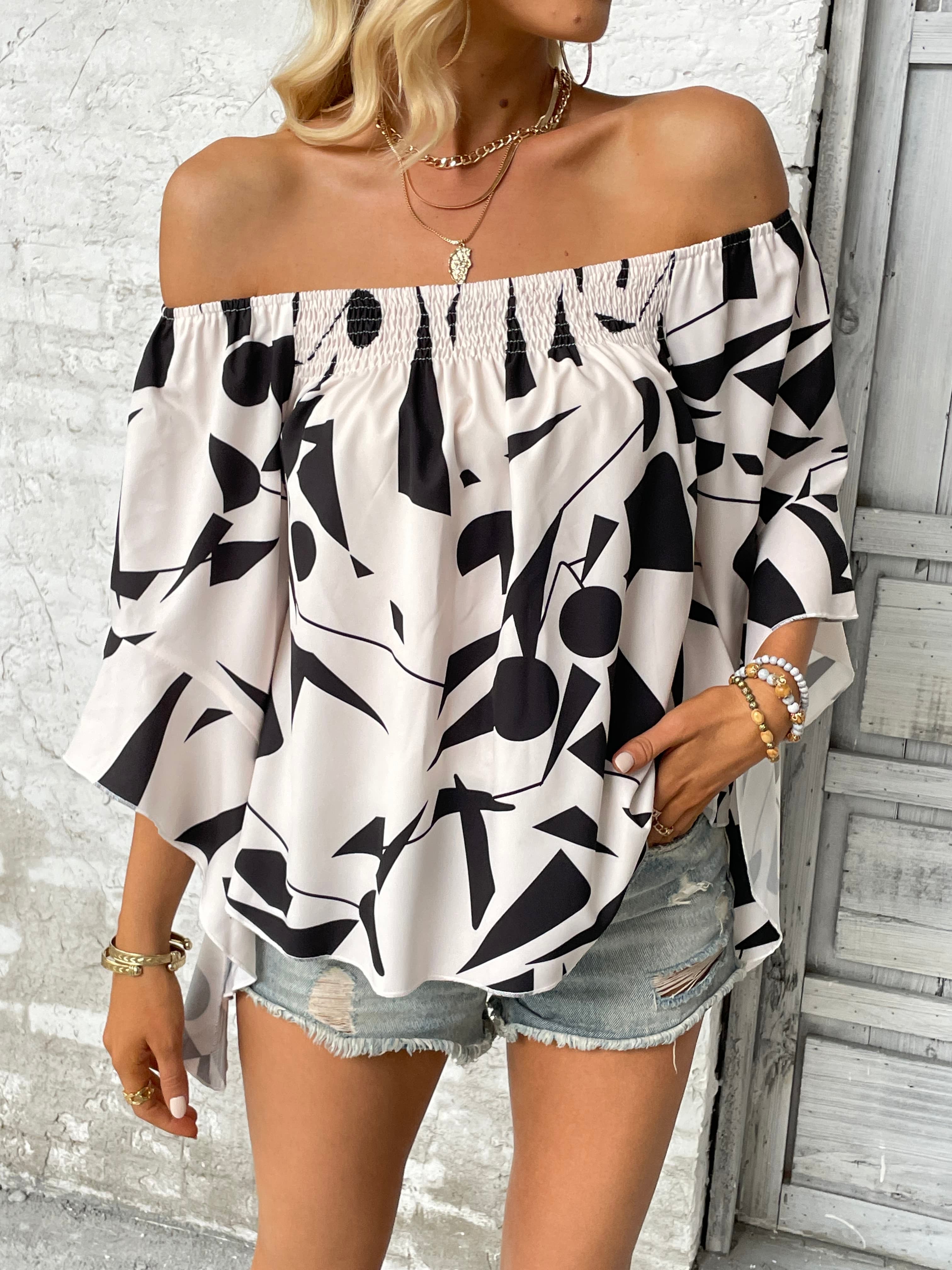 Off-shoulder geometric print blouse with flared sleeves and smocked neckline.