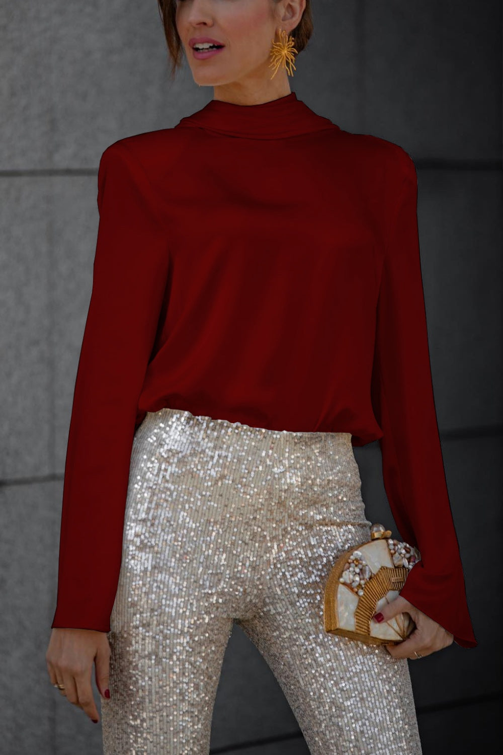 Burgundy silk blouse with high neck and long sleeves, paired with sequin pants.