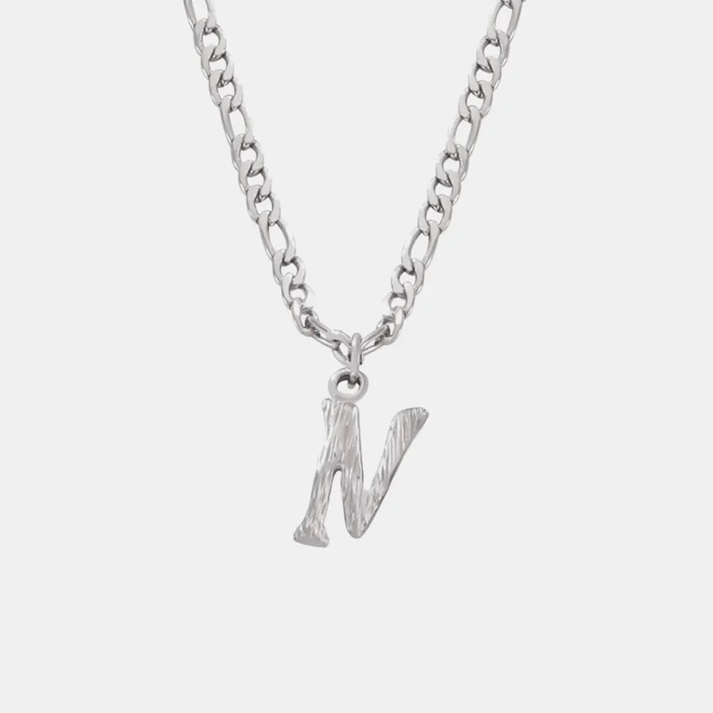 Silver initial pendant necklace with textured letter N on a figaro chain